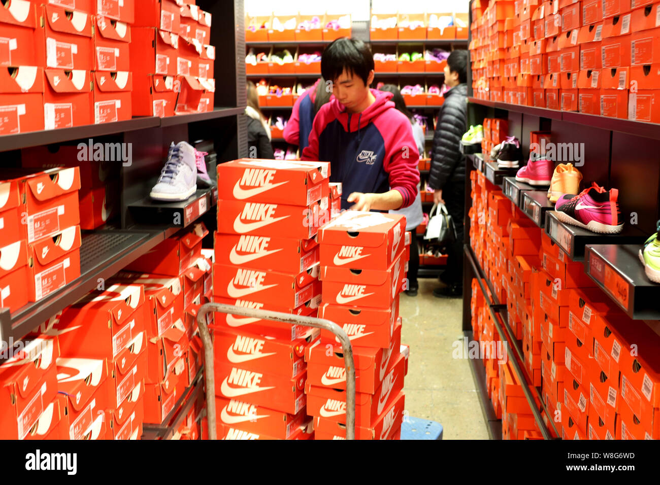FILE--A Chinese employee checks sneakers at a sportswear store of Nike in  Shanghai, China, 21 February 2015. China wants to develop its sports ind  Stock Photo - Alamy