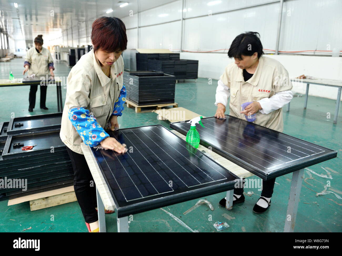 --FILE--Female Chinese workers clean solar panels at the plant of Shandong Hilight-Solar Co., Ltd. in Zouping county, Binzhou city, east China's Shand Stock Photo