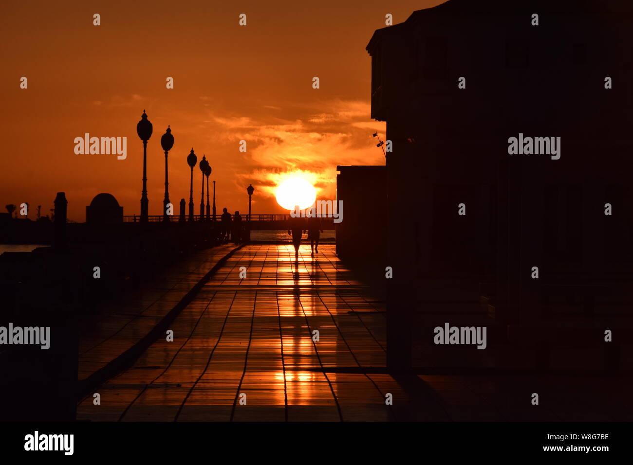 Couple walking together at sunset, on the seafront promenade of Arrecife, Lanzarote, Canary Islands, Spain - Stock Image