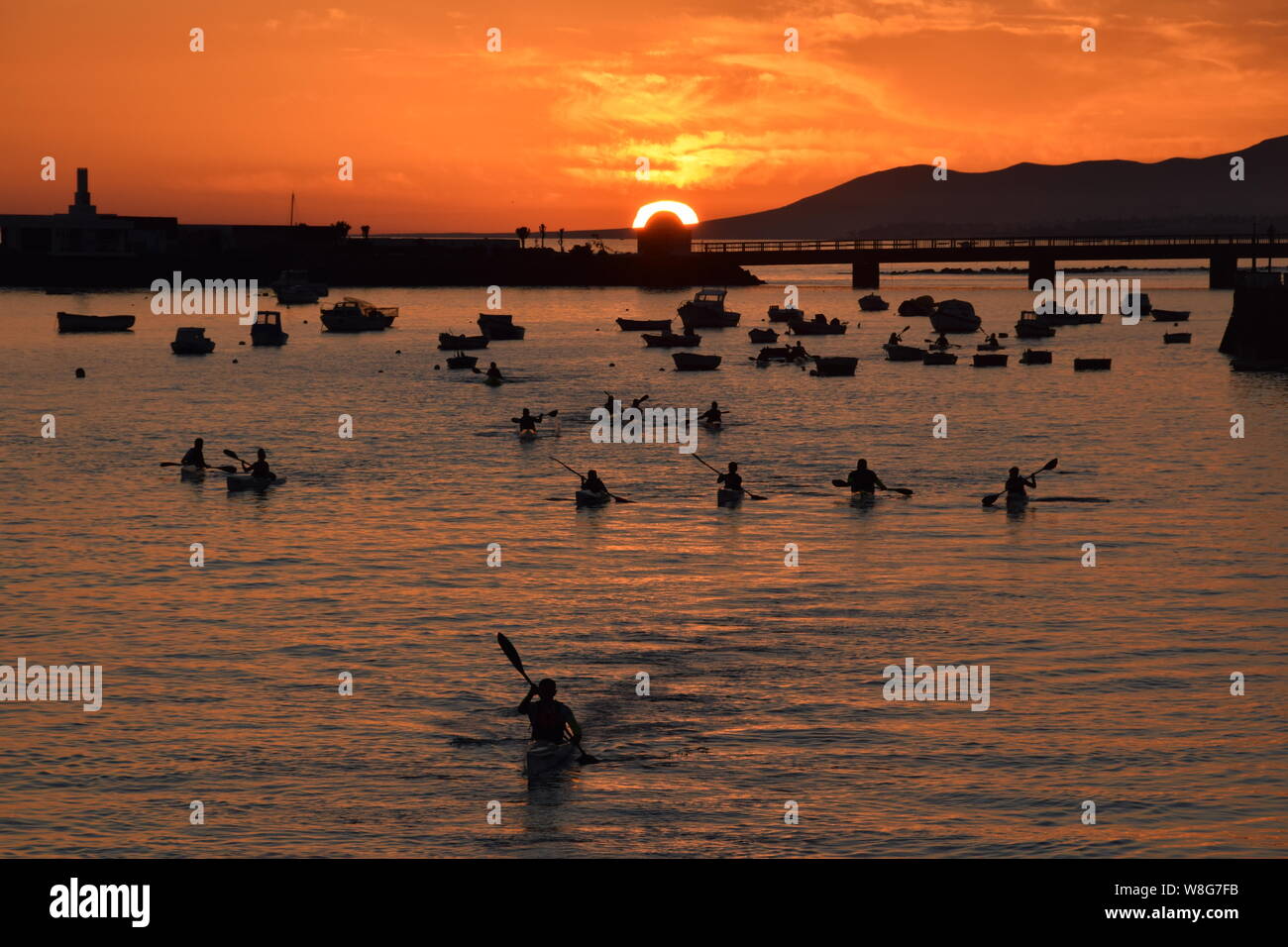 Kayakers at sunset in the sea at Arrecife, Lanzarote, Canary Islands, Spain - Stock Image