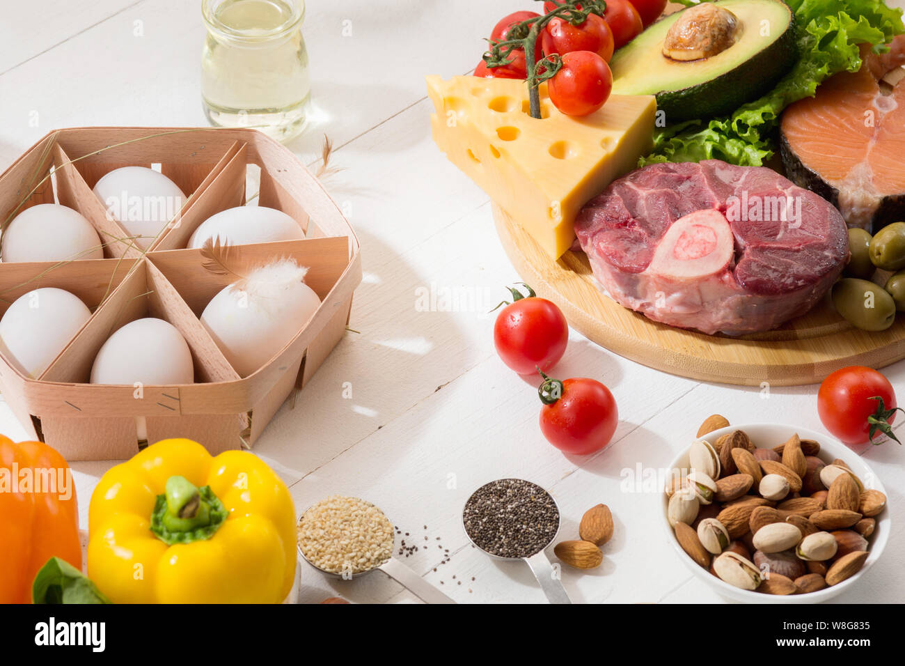 Ketogenic low carbs diet - food selection on white wooden background. Balanced healthy organic ingredients of high content of fats. Nutrition for the heart and blood vessels. Meat, fish and vegetables. Stock Photo