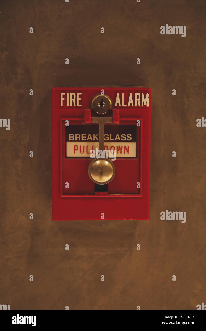 Fire alarm switch box on the wall. Emergency fire extinguisher sign alarm at hotel, hospital or office wall Stock Photo