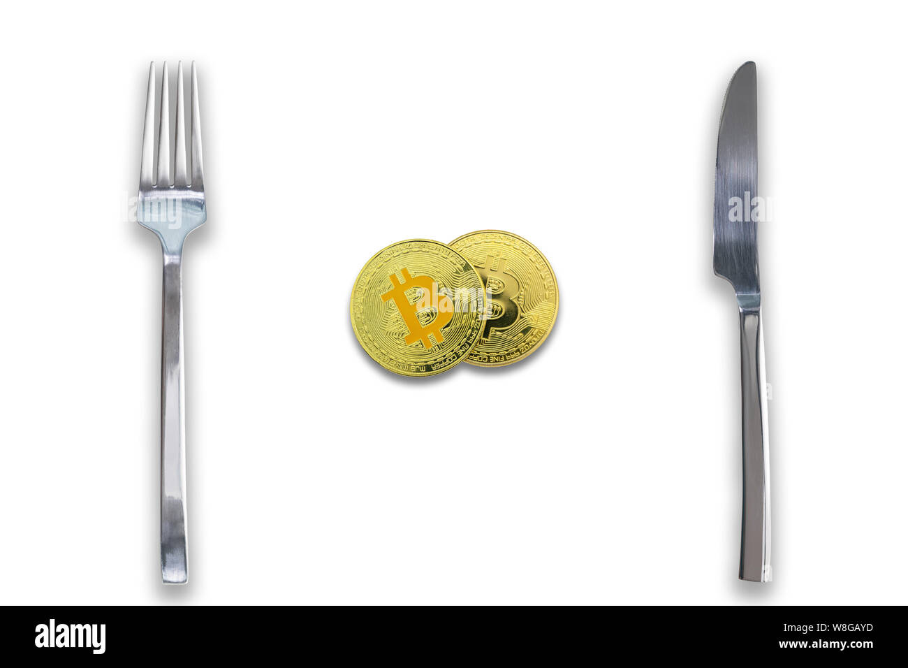 Two Bitcoins crypto currency between fork and knife. Concept of Bitcoin scalability problem. Cryptocurrency market deficit and limitations. Isolated w Stock Photo