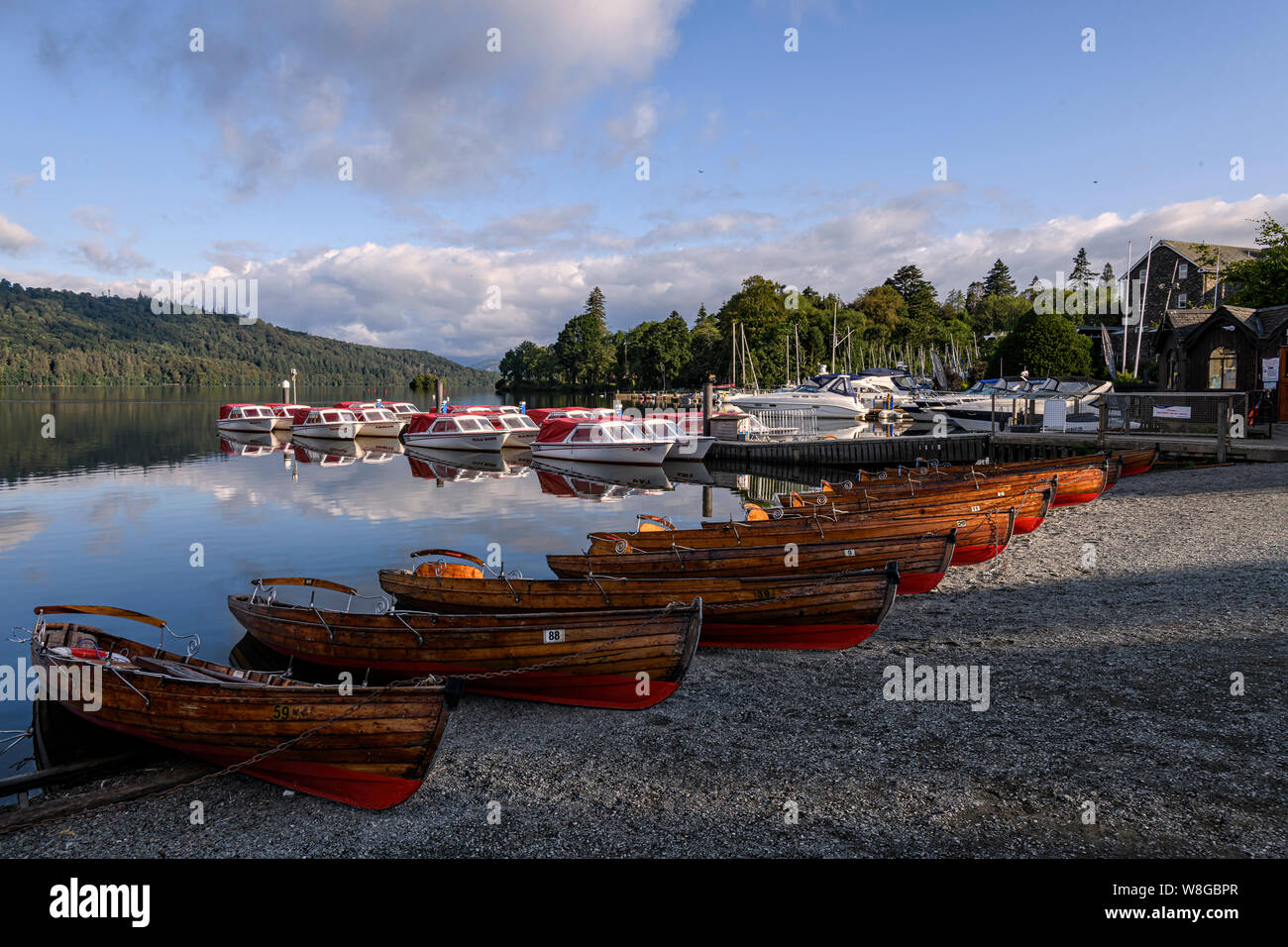 Electric lake cruisers and rowing boats for hire on Windermere along the promenade at Bowness-on-Windermere Stock Photo
