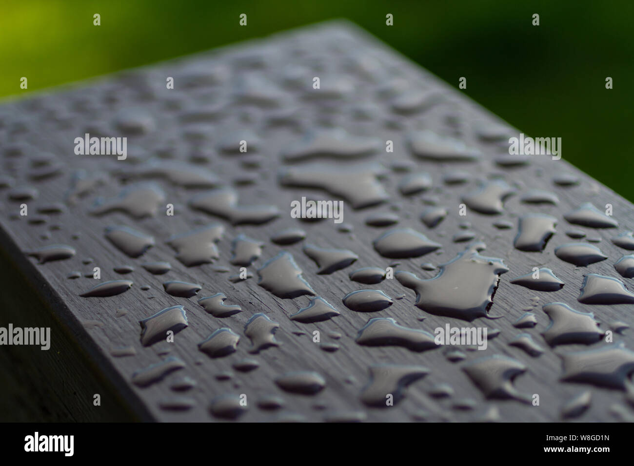 Close up of water beading on the surface of a freshly stained wooden hand railing. Stock Photo