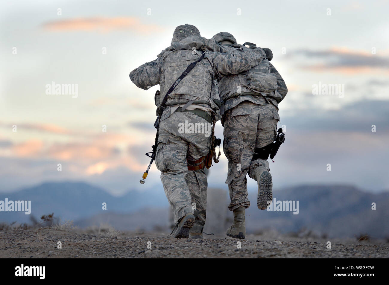 A U.S. soldier helping a fellow soldier during a training exercise Stock Photo