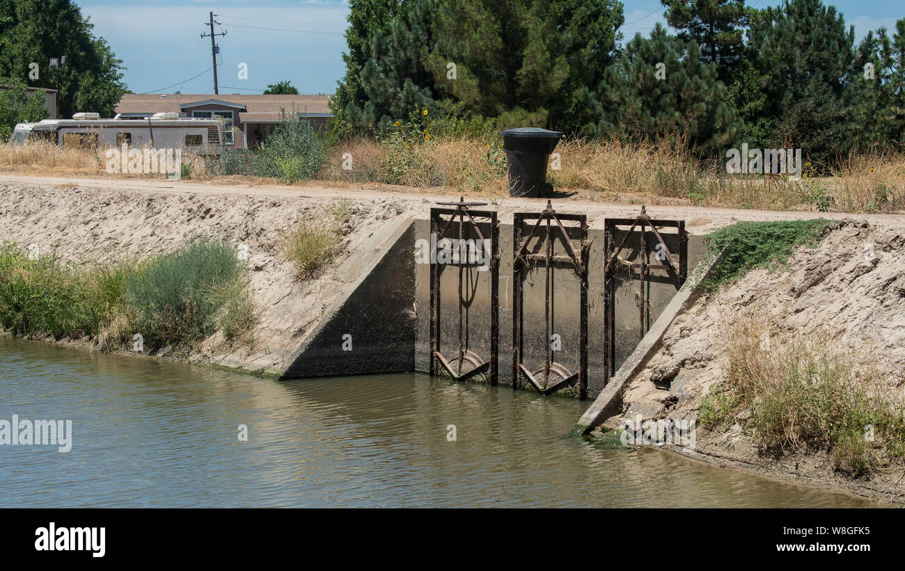 Surface waterways and flood irrigation flow valves have supplied irrigation water to drought-affected Livingston, CA on July 23, 2015. Stock Photo