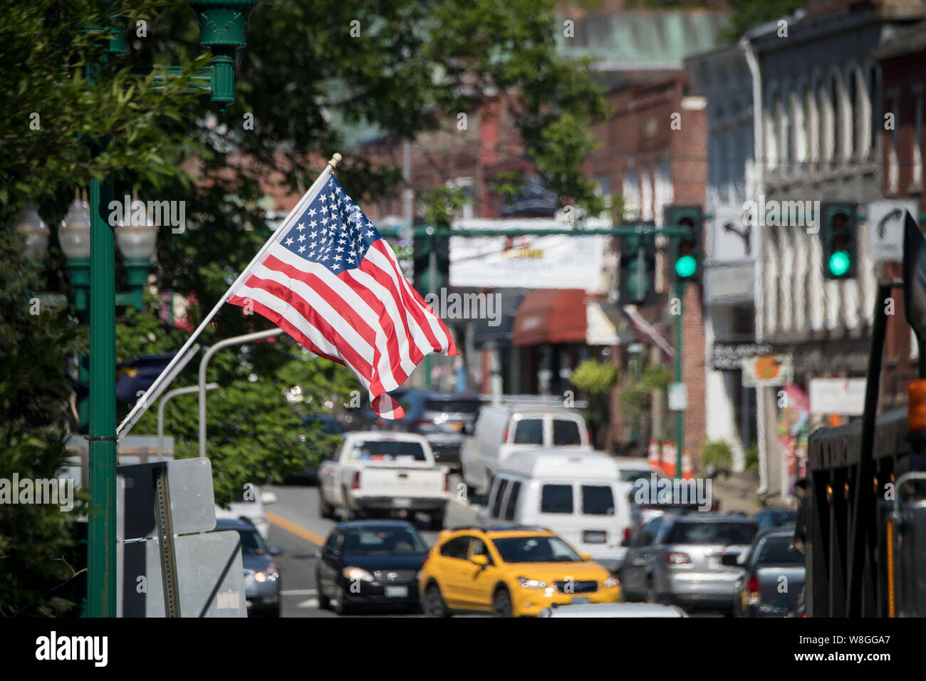 American flag waving along a busy street in Ellsworth, Maine on July 9, 2018. Stock Photo