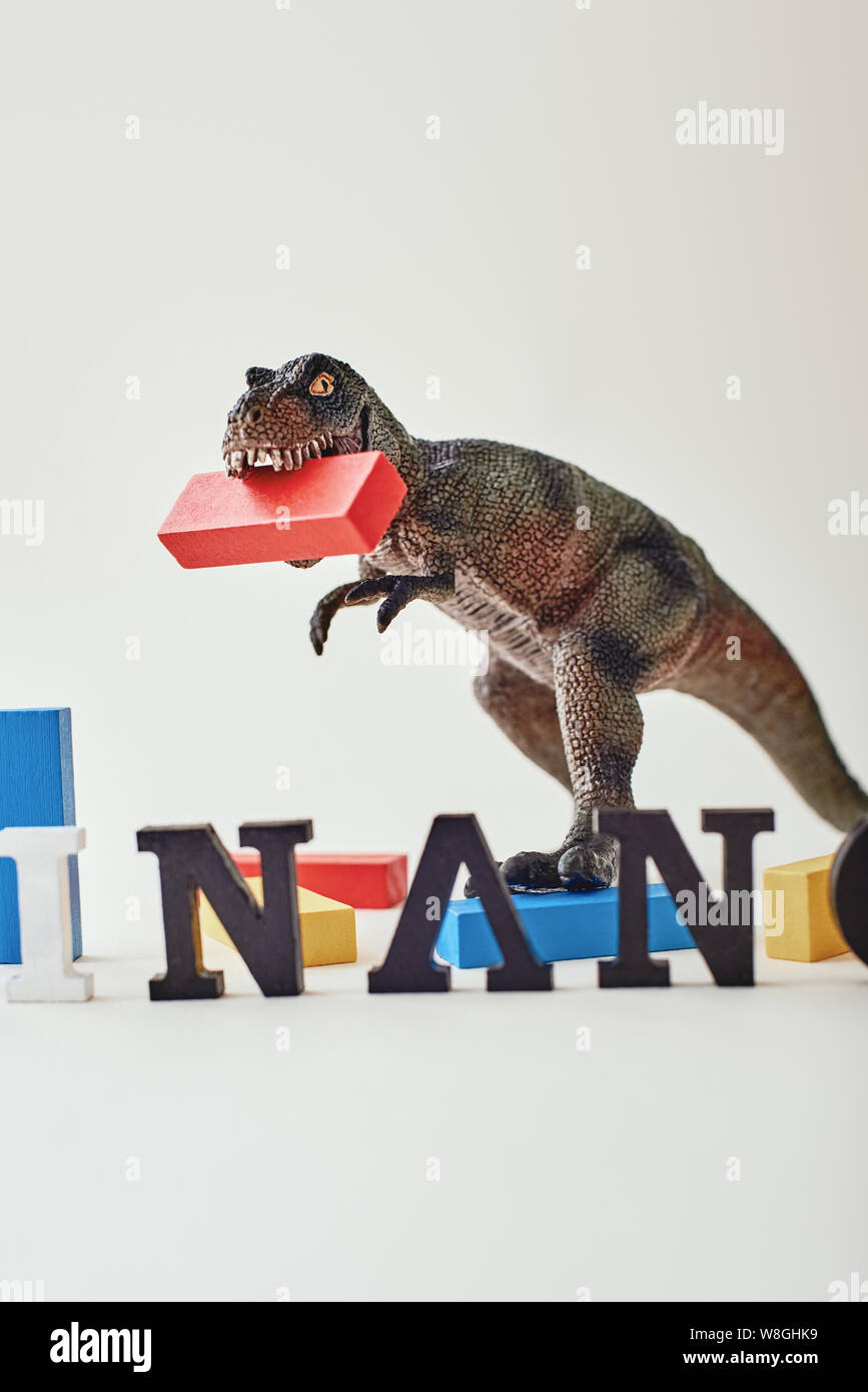 Close up of red, blue and yellow wooden blocks placed unevenly over light  background near dinosaur toy. Word Finance made of wooden letters standing  i Stock Photo - Alamy