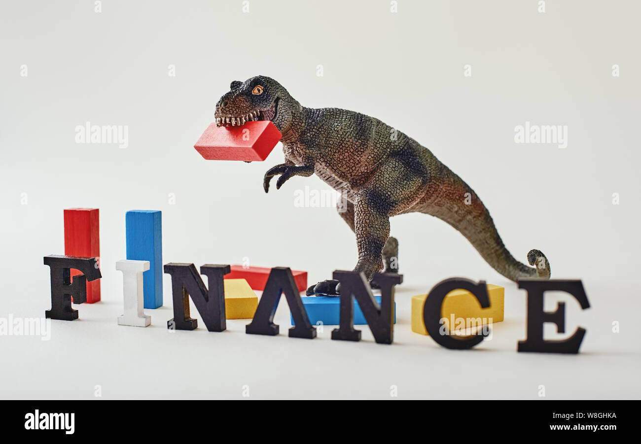 Red, blue and yellow wooden blocks placed unevenly over light near dinosaur toy. Finance made of wooden letters standing in a row. Horizontal shot Photo - Alamy