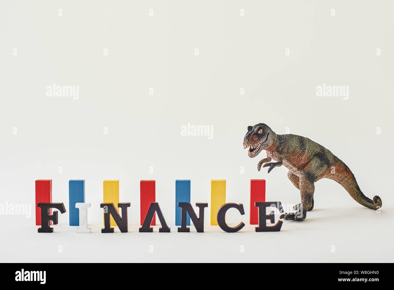 Red, blue and yellow wooden blocks of same height standing over light  background near dinosaur toy. Word Finance made of wooden letters standing  in a row. Horizontal shot Stock Photo - Alamy
