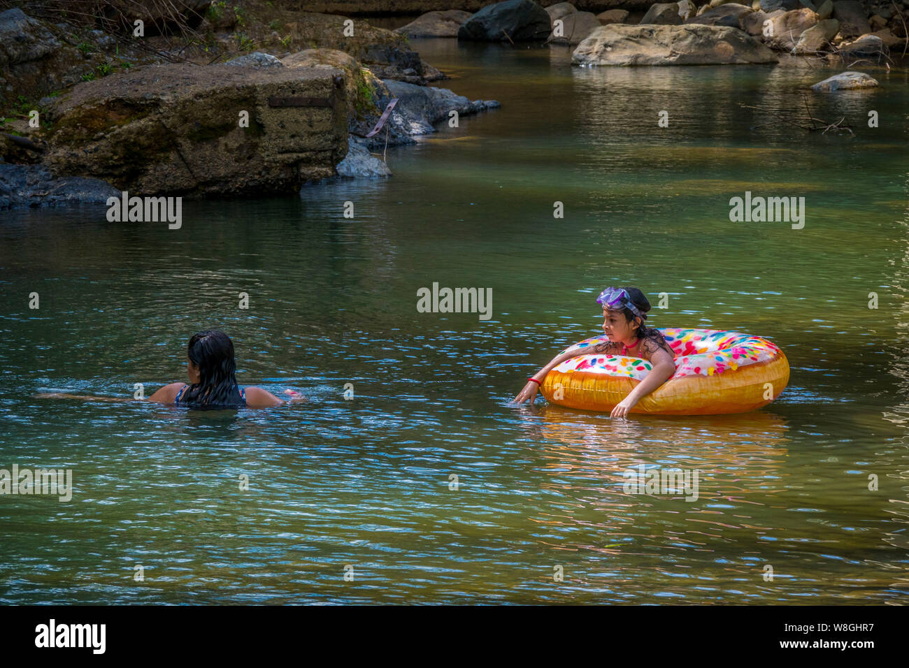 Tourists enjoying swimming in a river in El Yunque National Forest in