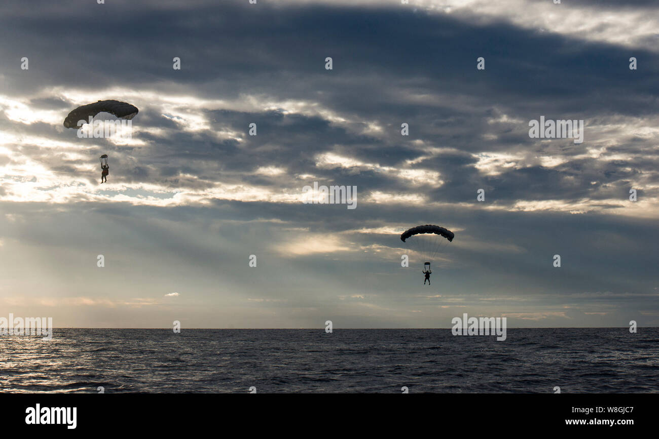 U.S. Air Force Airmen from the 320th Special Tactics Squadron at Kadena Air Base, Japan, parachute into the Pacific Ocean at dawn Nov. 22, 2016 Stock Photo