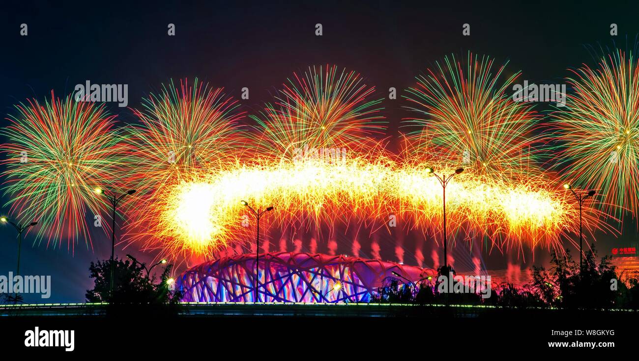 Fireworks explode over the Beijing National Stadium, back, also known