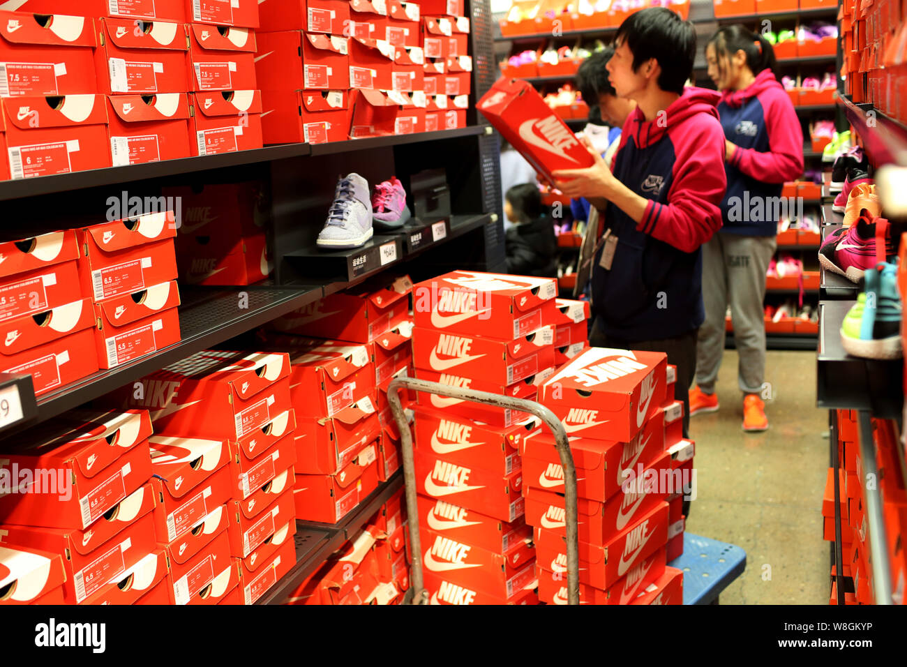 FILE--A Chinese employee checks shoes at a sportswear store of Nike in  Shanghai, China, 21 February 2015. Interest in U.S. earnings will pick up t  Stock Photo - Alamy