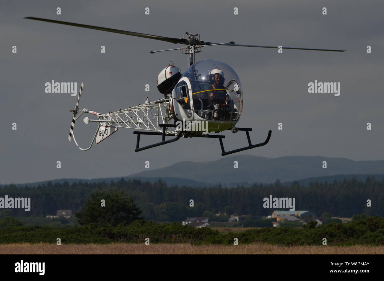 A 1961 Bell 47G-5 helicopter arriving at the Light Aircraft Association's 2019 annual fly-in event at Dornoch Airstrip, Scottish Highlands, UK. Stock Photo