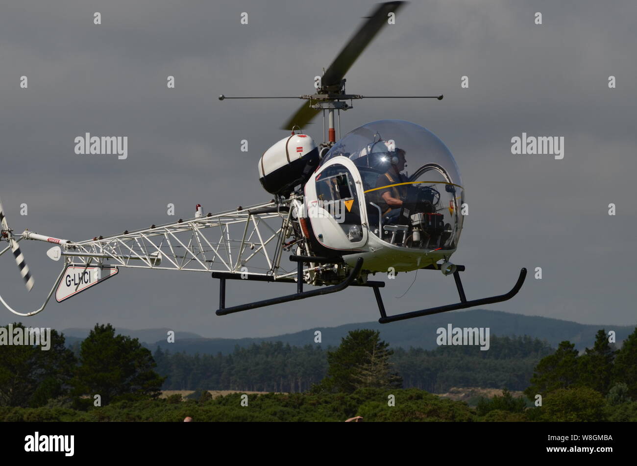 A 1961 Bell 47G-5 helicopter arriving at the Light Aircraft Association's 2019 annual fly-in event at Dornoch Airstrip, Scottish Highlands, UK. Stock Photo