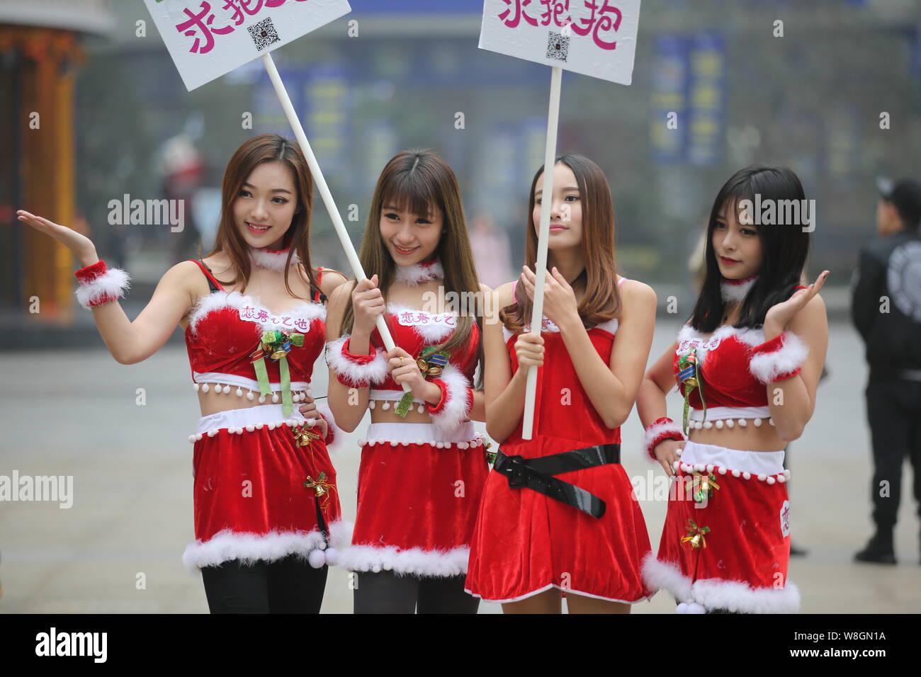 Young Chinese girls dressed in Christmas costumes pose as they seek ...