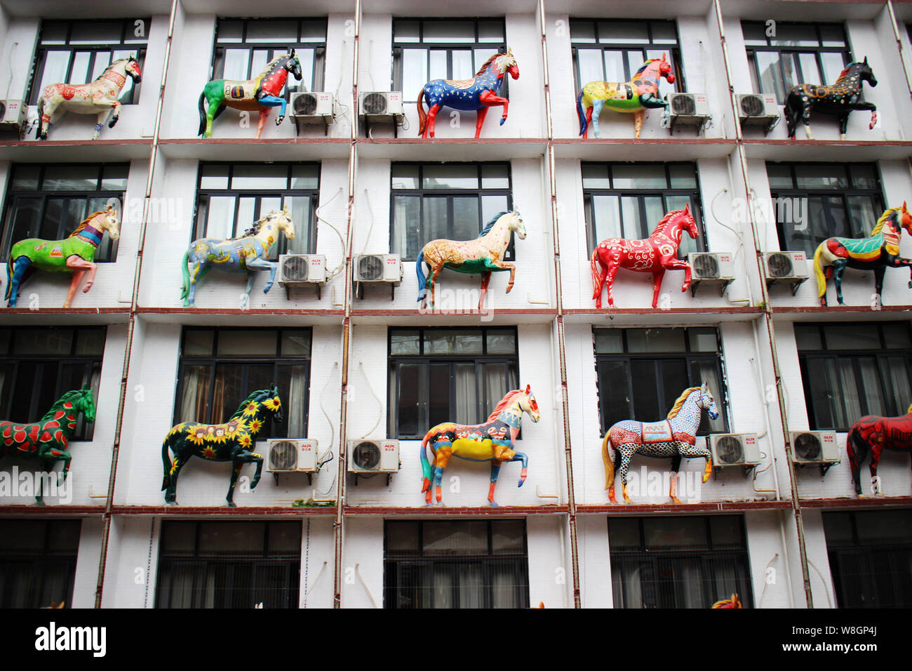 Horse sculptures are on display outside the windows of guest rooms in a hotel building in Chongqing, China, 21 November 2015.   Though the Year of the Stock Photo