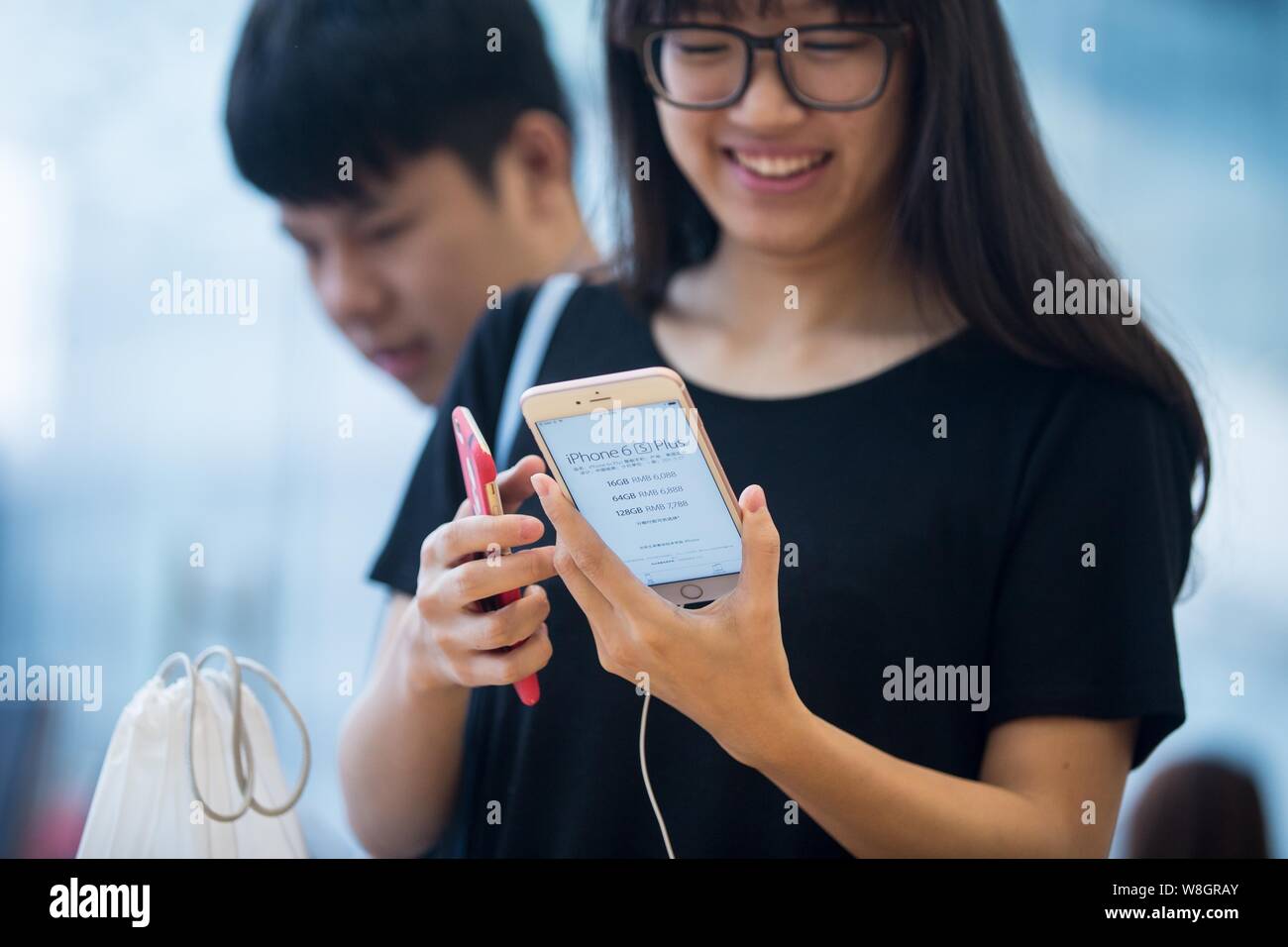 A customer tries out a rose gold iPhone 6s Plus smartphone at the Apple Store near the West Lake in Hangzhou city, east China's Zhejiang province, 25 Stock Photo