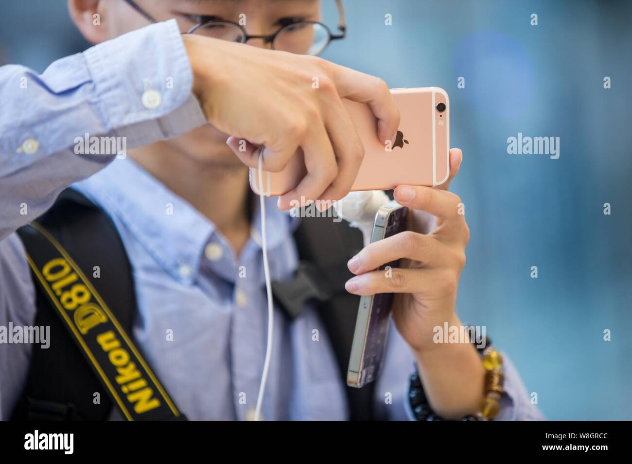 A customer tries out a rose gold iPhone 6s smartphone at the Apple Store near the West Lake in Hangzhou city, east China's Zhejiang province, 25 Septe Stock Photo