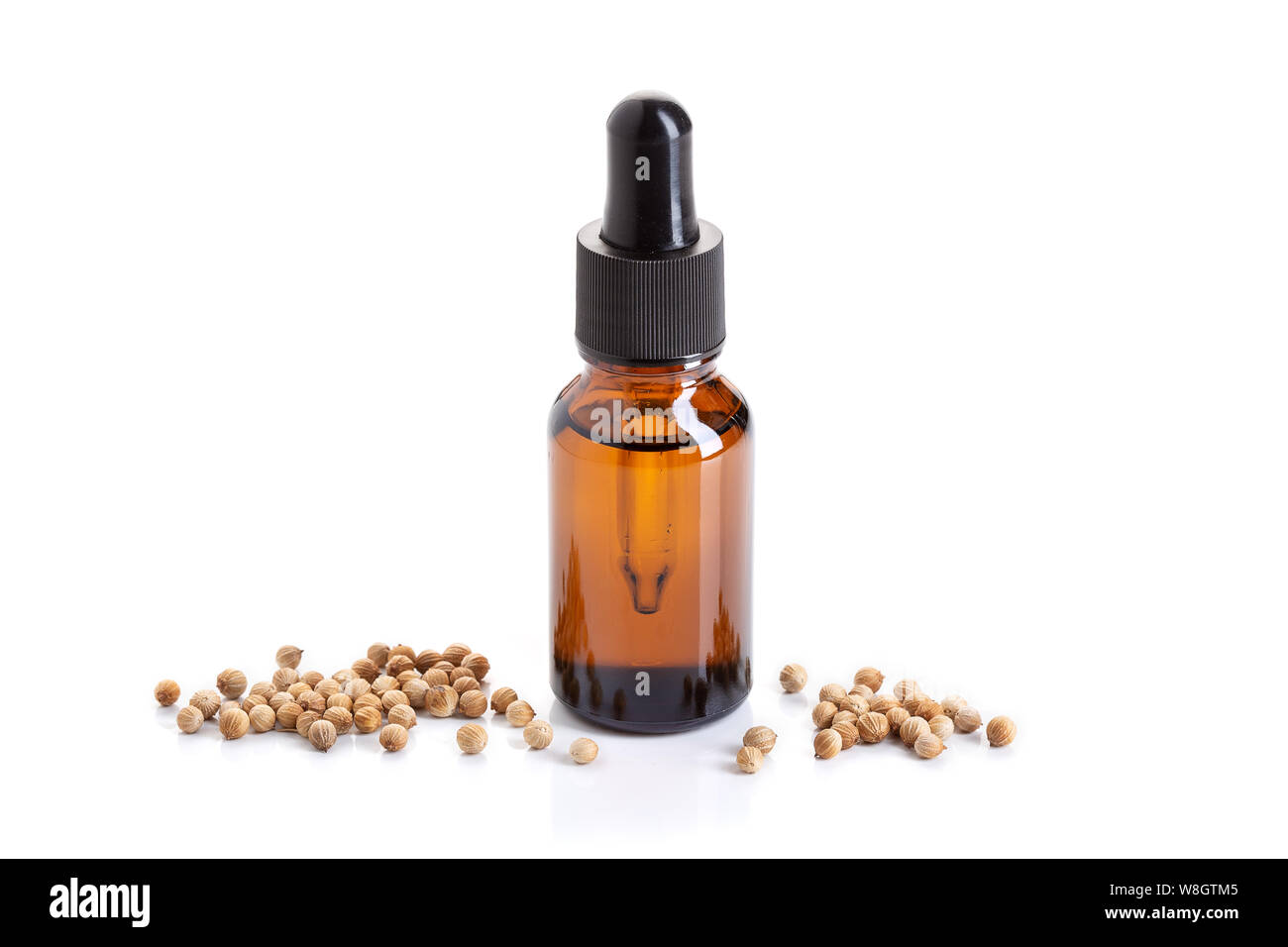 Coriander essential oil with coriander seeds isolated on white