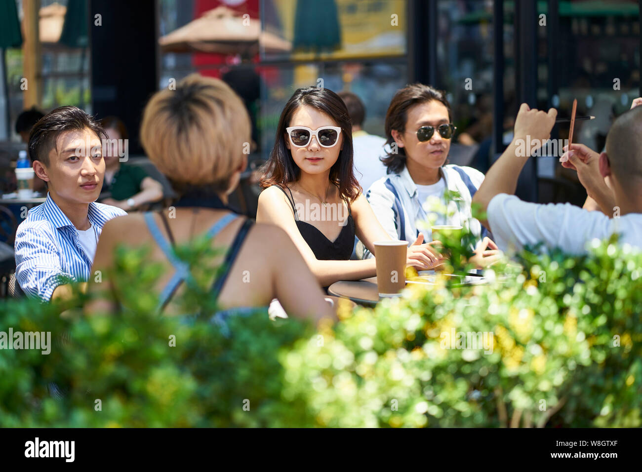 young asian adult friends gathering relaxing in outdoor coffee shop Stock Photo