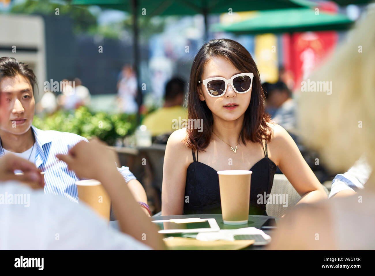 young asian adult friends gathering relaxing in outdoor coffee shop Stock Photo