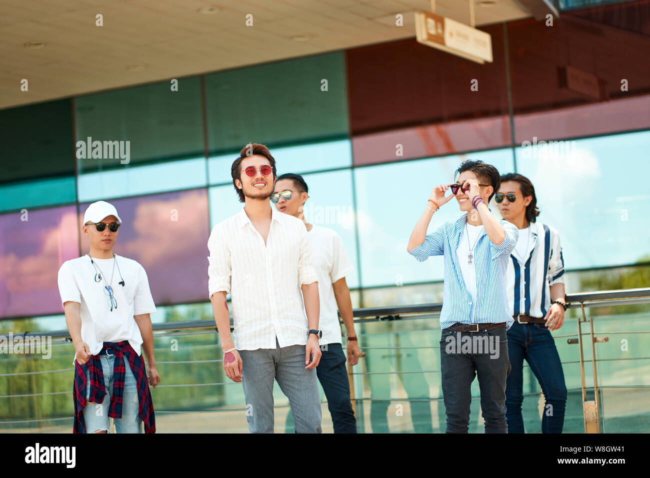 a group of five young asian adults hanging out together walking on street Stock Photo