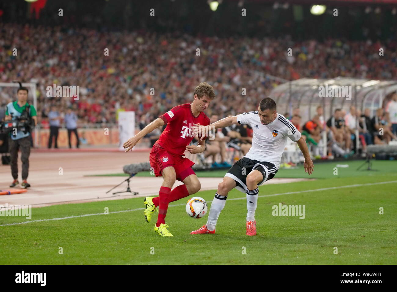 Thomas Mueller of Bayern Munich, left, challenges Javi Fuego of FC Valencia during their friendly soccer match in Beijing, China, 18 July 2015.   Thom Stock Photo