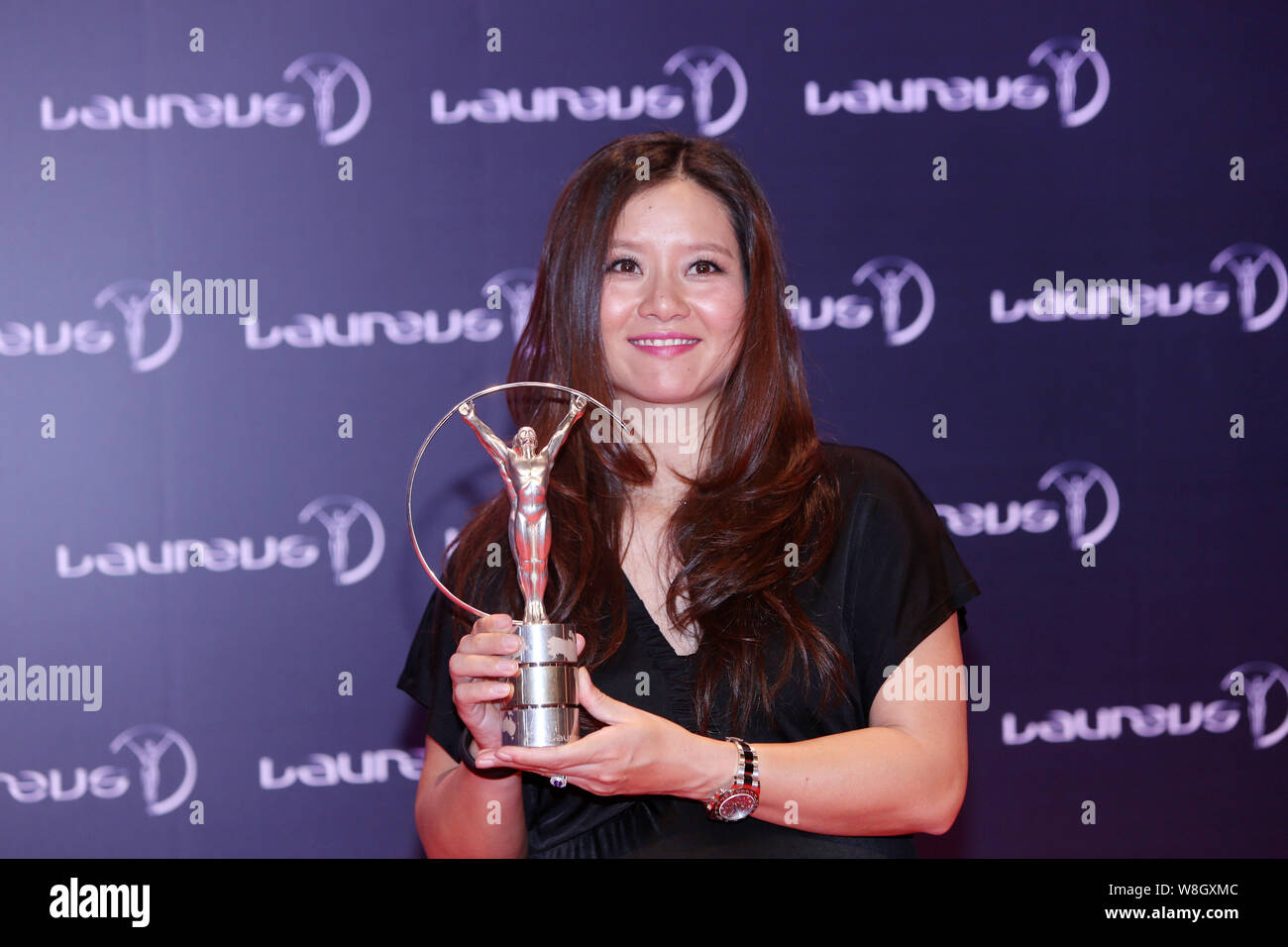 --FILE--Retired Chinese tennis star Li Na poses with her trophy after the award ceremony for the Laureus World Sports Awards Shanghai 2015 in Shanghai Stock Photo