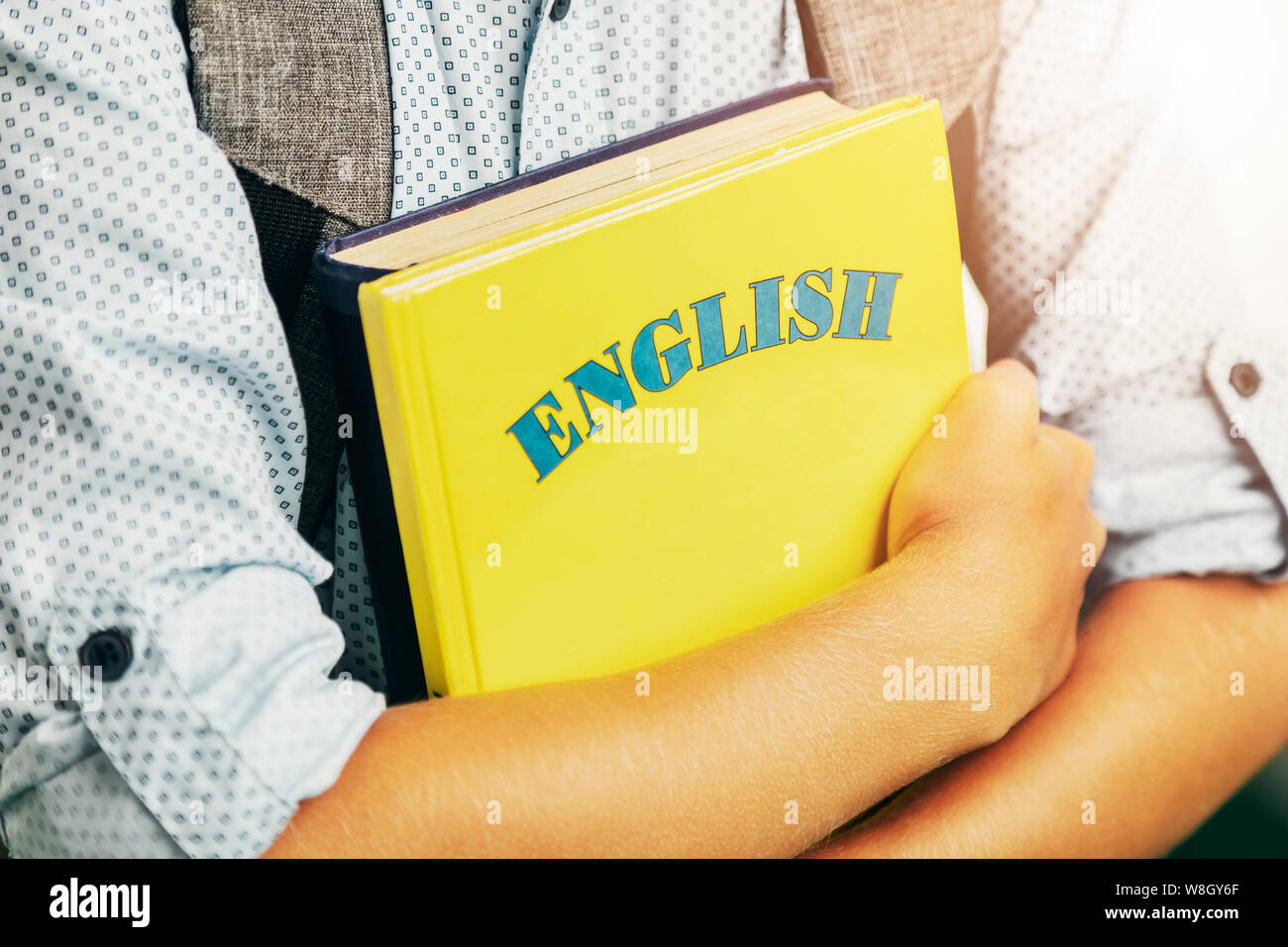 Boy with backpack holding English books closeup Stock Photo