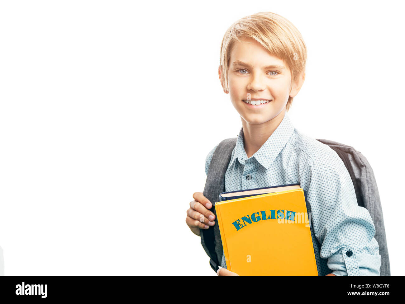 A smiling English student with a schoolbag and books lit by Sun Stock Photo