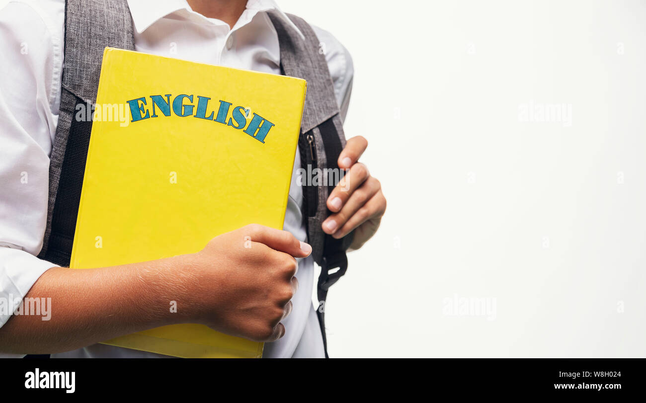 Schoolboy with a schoolbag carrying an English book closeup Stock Photo