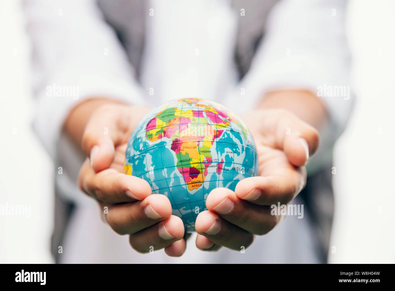Blurred kid holding a globe in stretched hands closeup Stock Photo