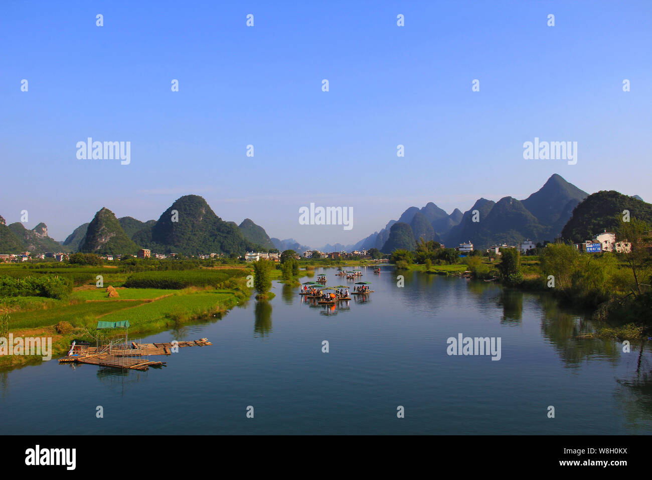 --FILE--Tourists take bamboo rafts along the Yulong River through karst hills in Yangshuo county, Guilin city, south China's Guangxi Zhuang Autonomous Stock Photo