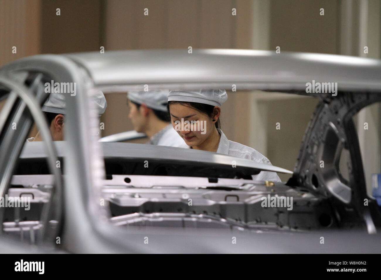 --FILE--A female Chinese worker assembles a car on the assembly line at ...