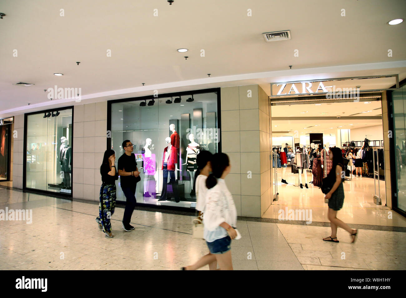 --FILE--Pedestrians walk past a store of Zara at a shopping mall in Shanghai, China, 1 September 2015.   Spanish fast fashion retailer Inditex posted Stock Photo