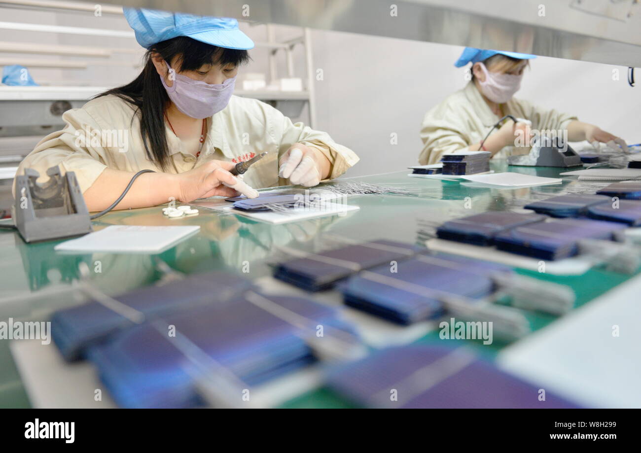 --FILE--Female Chinese workers weld photovoltaic cells to make solar panels at the plant of Shandong Hilight-Solar Co., Ltd. in Zouping county, Binzho Stock Photo