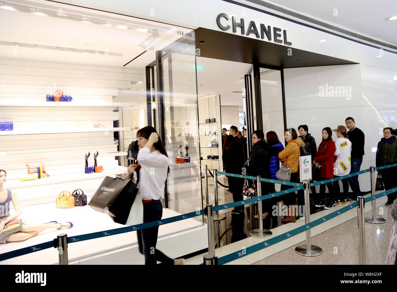 FILE--Customers queueing at the entrance of the fashion boutique of Chanel  watch a trendy young woman leaving after shopping inside the store at the  Stock Photo - Alamy