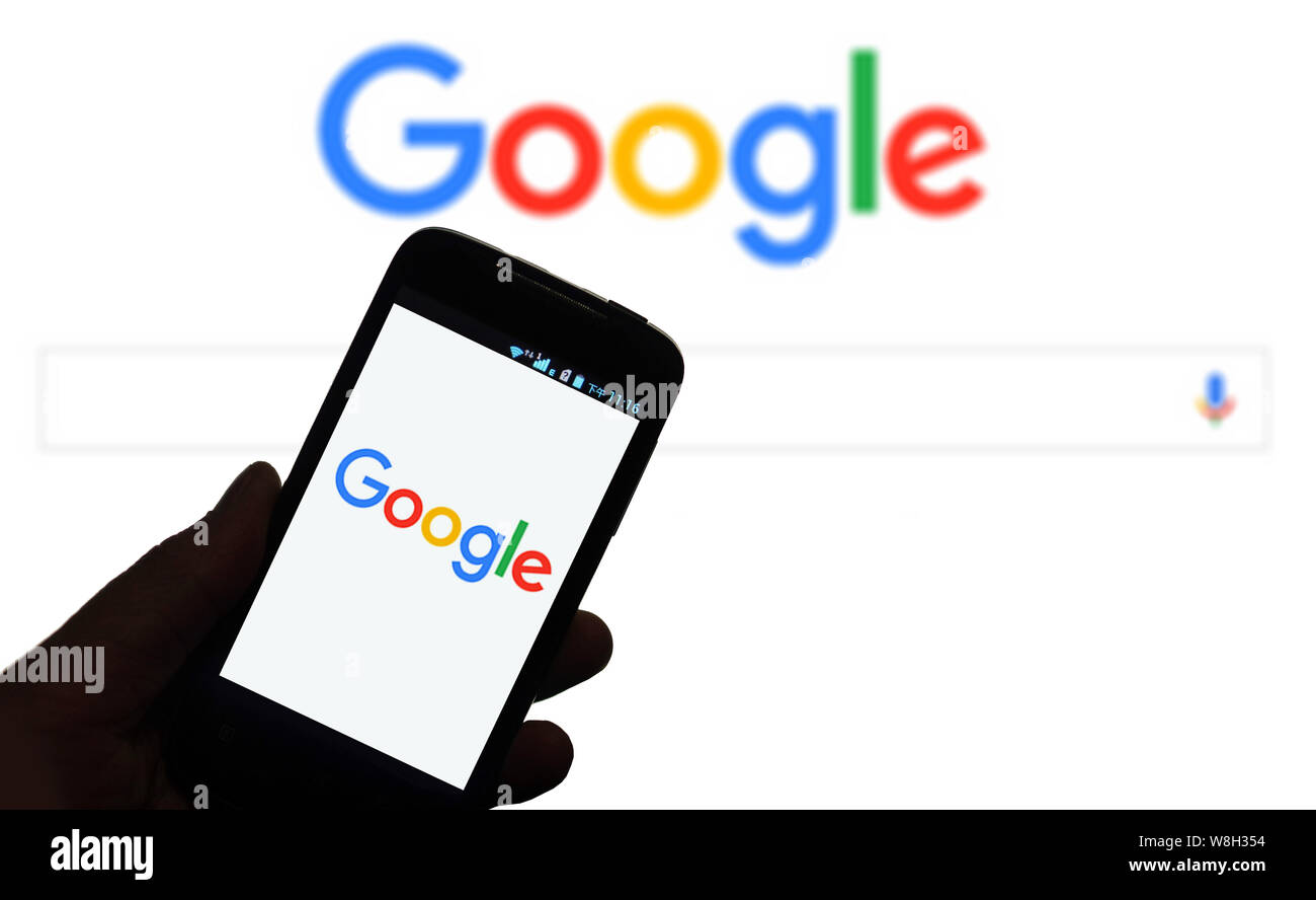 --FILE--A mobile phone user shows the logo of Google on his smartphone in Jinan city, east China's Shandong province, 15 February 2015.  Alphabet Inc. Stock Photo
