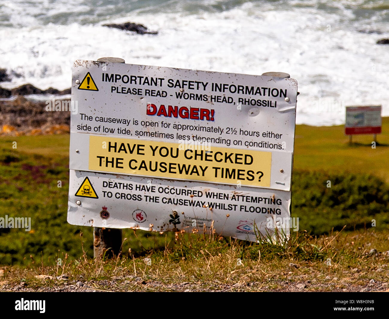 Safety warning sign for people who wish to cross the causeway to Worms Head, Rhossili. AONB, Gower, Wales, UK. Stock Photo