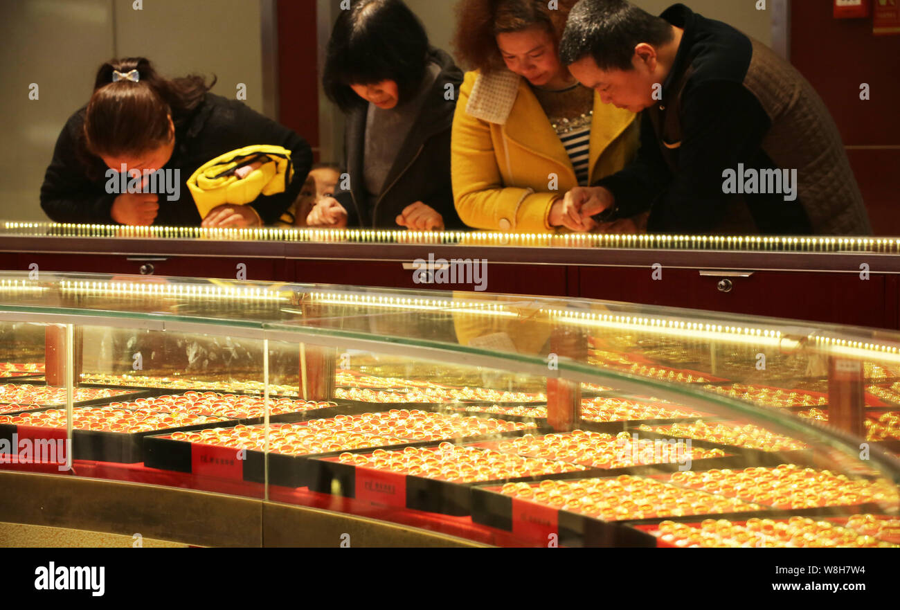 --FILE--Chinese customers shop for gold ornaments at a jewelry store in ...