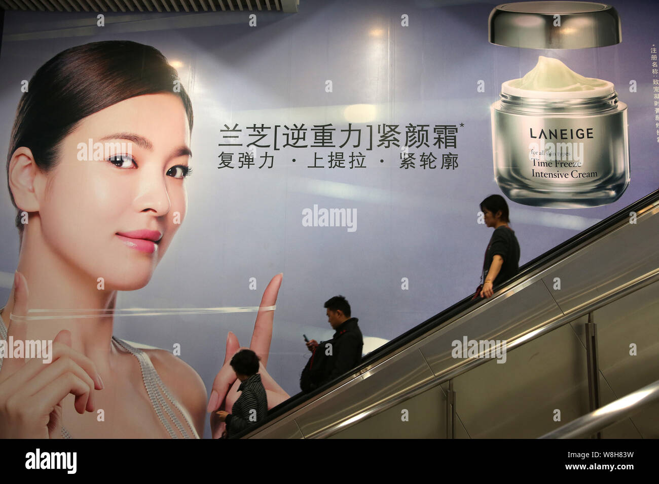 --FILE--Passengers take an escalator past an advertisement for South Korean's Laneige Intensive Cream at a metro station in Shanghai, China, 20 Novemb Stock Photo