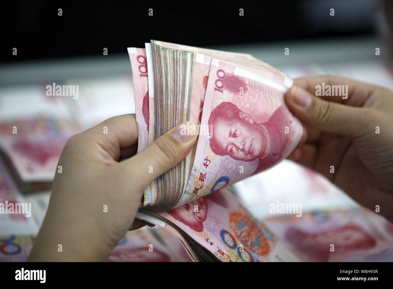 Counting Rmb --FILE--A Chinese clerk counts RMB (renminbi) yuan banknotes at a bank ...