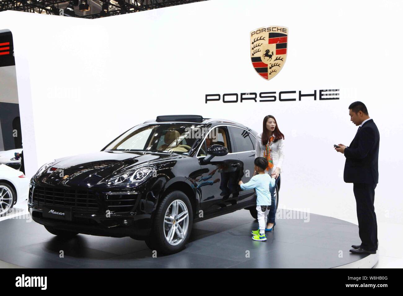 --FILE--Visitors look at a Porsche Macan during an automobile exhibition in Tianjin, China, 3 October 2014.   Foreign investment into China accelerate Stock Photo