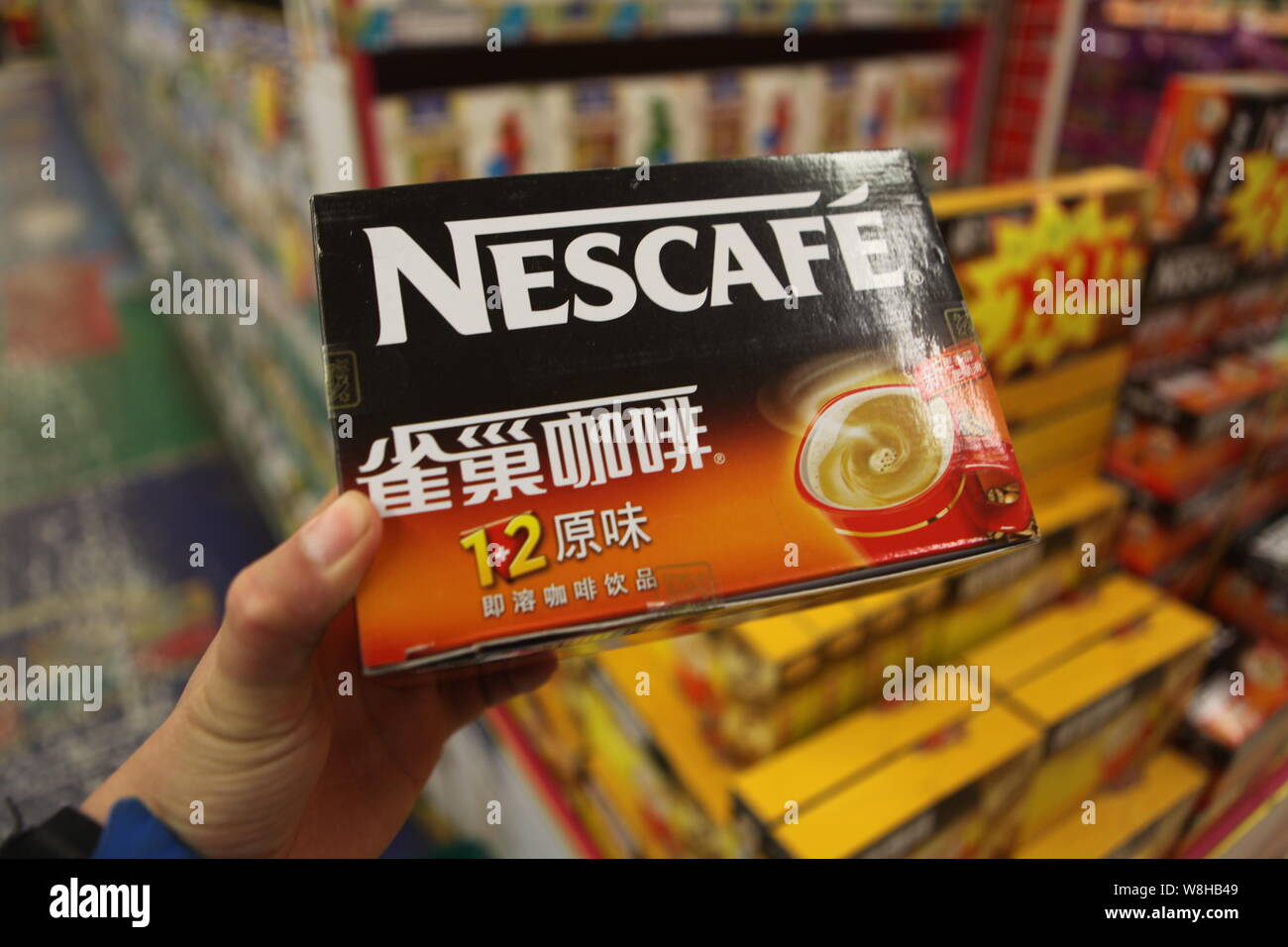 --FILE--A customer buys a carton of Nescafe instant coffee of Nestle at a supermarket in Rizhao city, east Chinas Shandong province, 8 March 2014. Stock Photo