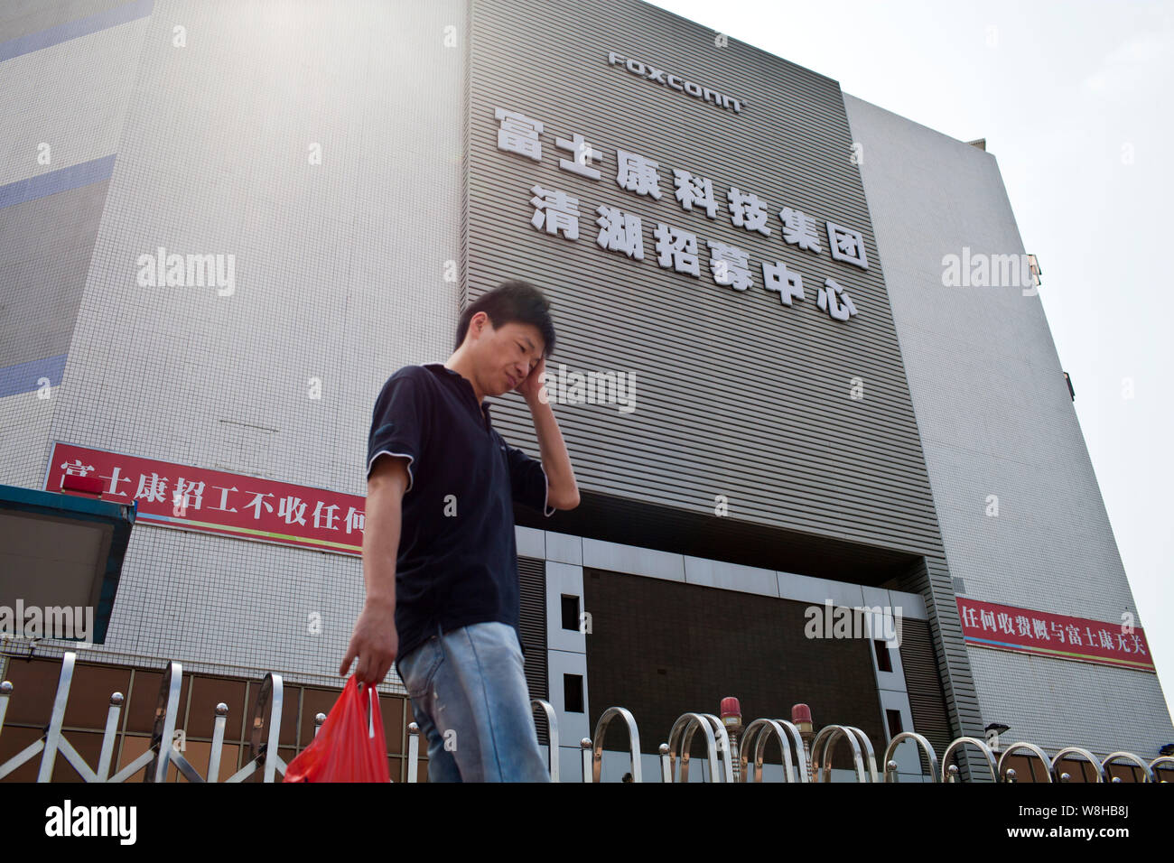 --FILE--A pedestrian walks past a recruitment center of Foxconn Technology Group in Shenzhen city, south Chinas Guangdong province, 19 February 2013. Stock Photo