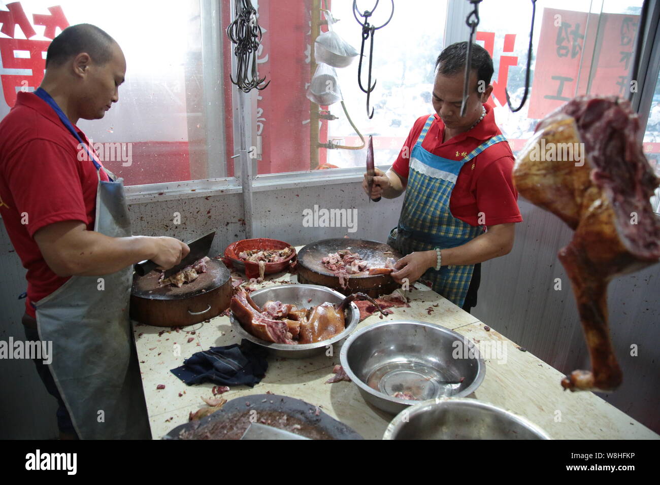 Cooks chop dog meat at a restaurant during the Yulin Dog Eating Festival in Yulin city, south China's Guangxi Zhuang Autonomous Region, 22 June 2015. Stock Photo