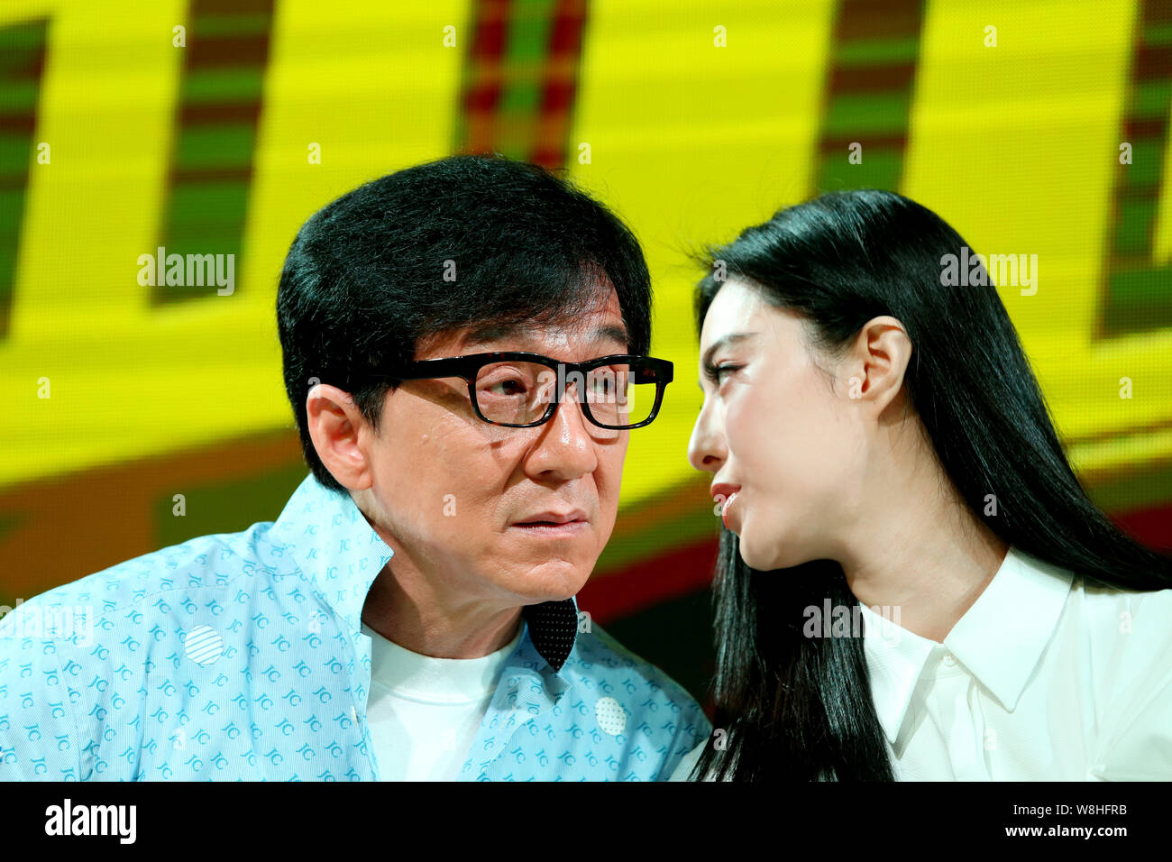 Chinese actress Fan Bingbing, right, whispers to Hong Kong action star Jackie Chan at a press conference for their movie 'Skiptrace' during the 18th S Stock Photo